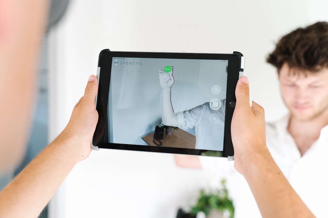 Professional real estate agent stands in a bright, modern living room, using a digital tablet to showcase property feature...