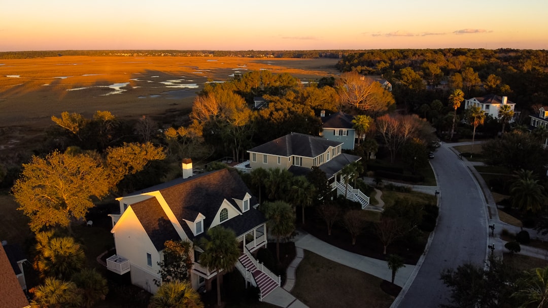A beautiful, well-maintained suburban home, typical of the Gulf South, stands securely under a clear blue sky, its pristine roof protecting it from harsh weather.