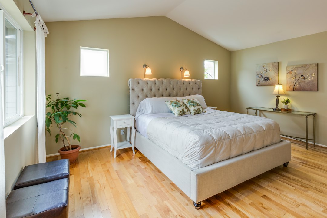 An inviting and serene bedroom filled with natural light from a large window, showcasing how light makes a space feel welcoming.